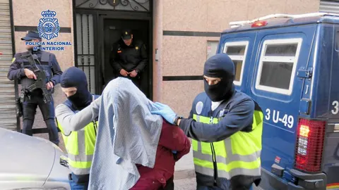 Agentes de Policía conducen a uno de los detenidos en la operación en la que se desmanteló el centro yihadista