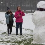 Un grupo de jóvenes se fotografía con un muñeco de nieve