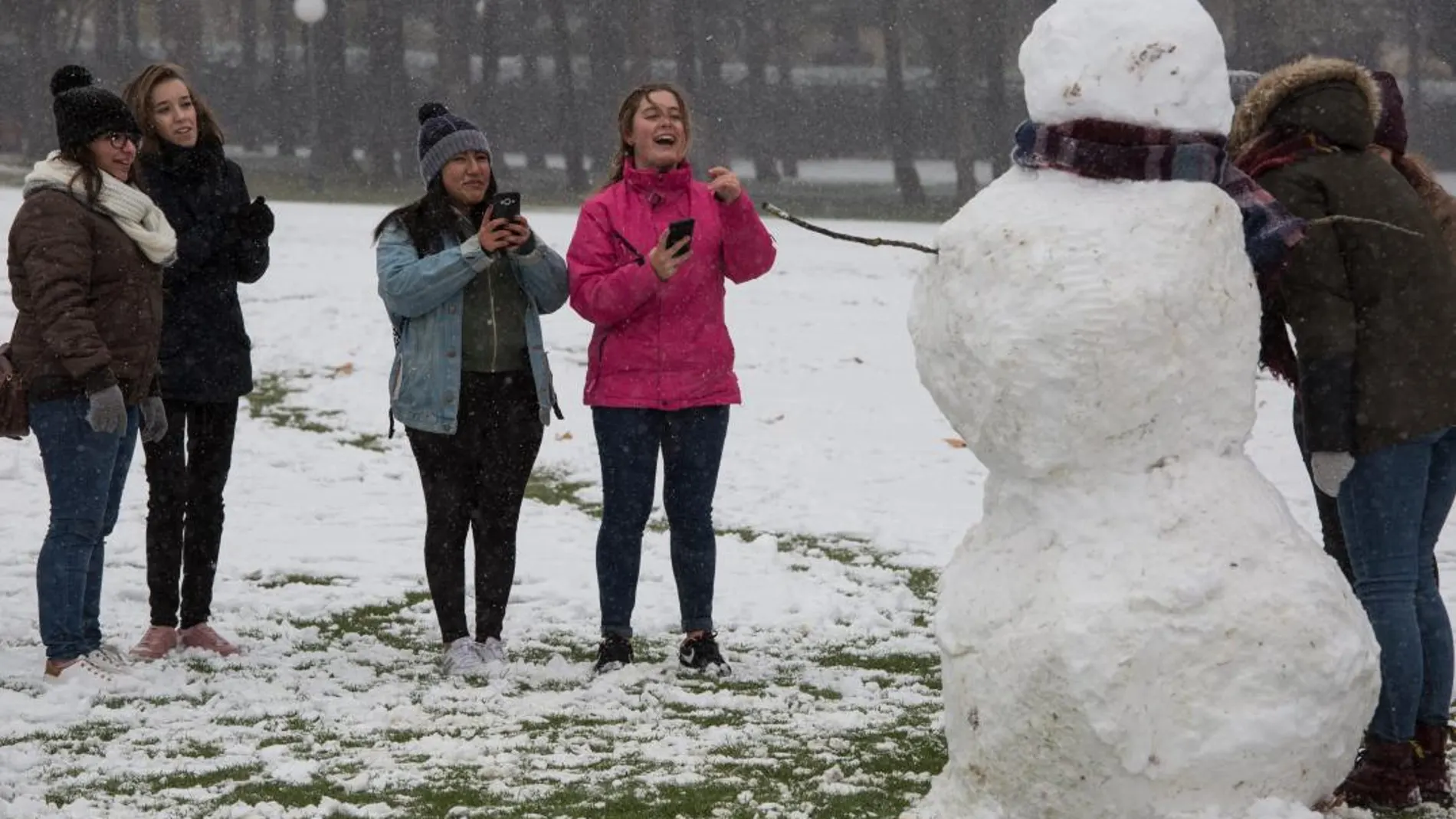 Un grupo de jóvenes se fotografía con un muñeco de nieve