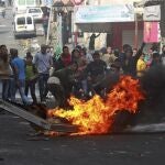 Varios palestinos queman ruedas para crear una barricada tras los disturbios desatados tras el funeral de Arafat Yaradat, celebrado en Sair, cerca de Hebrón, Cisjordania hoy 25 de febrero de 2013.
