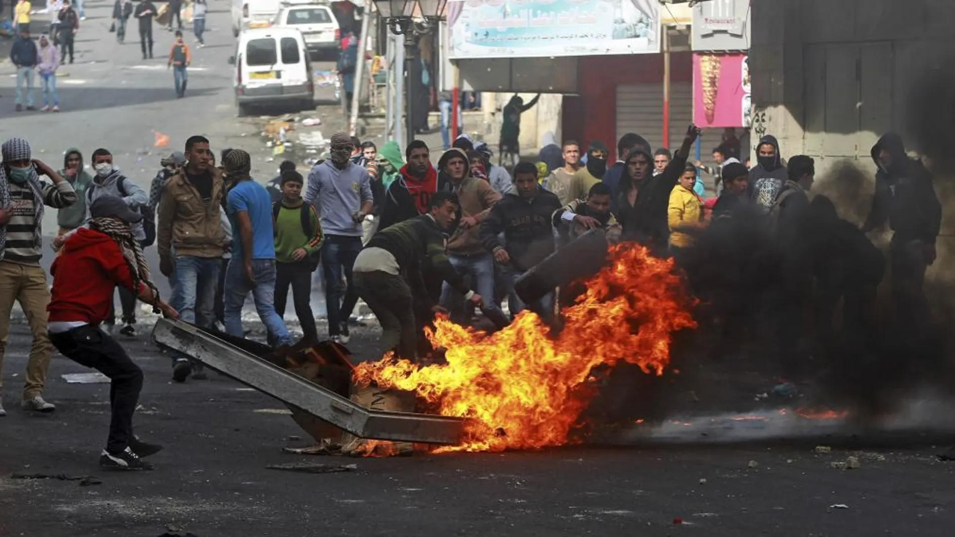 Varios palestinos queman ruedas para crear una barricada tras los disturbios desatados tras el funeral de Arafat Yaradat, celebrado en Sair, cerca de Hebrón, Cisjordania hoy 25 de febrero de 2013.