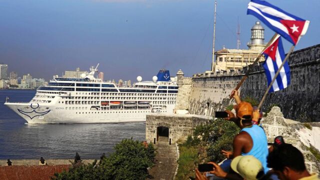 Un grupo de cubanos ondean banderas a la llegada al puerto de La Habana del «Adonia»
