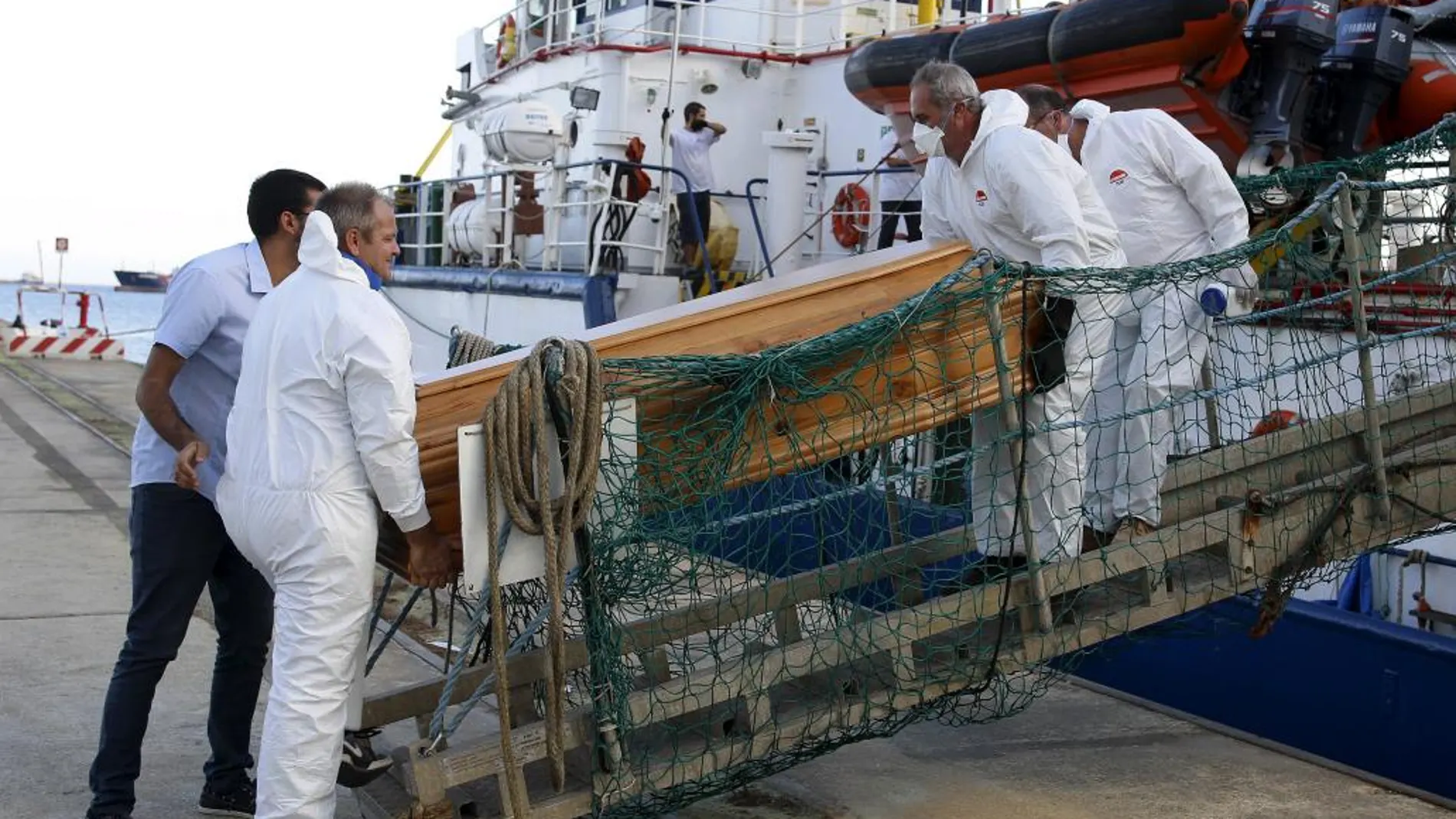 El féretro de un inmigrante es desembarcado de un barco de Médicos Sin Fronteras ayer