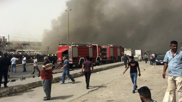 Policías y civiles en la zona de un atentado suicida en el barrio chií de Nuevo Bagdad