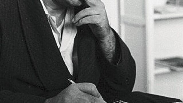Camilo José Cela apura un cigarrillo mientras piensa en uno de sus textos