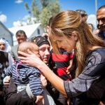 La reina de Jordania acaricia a un bebé durante su visita al compo de refugiados de Kara Tepe, en Lesbos