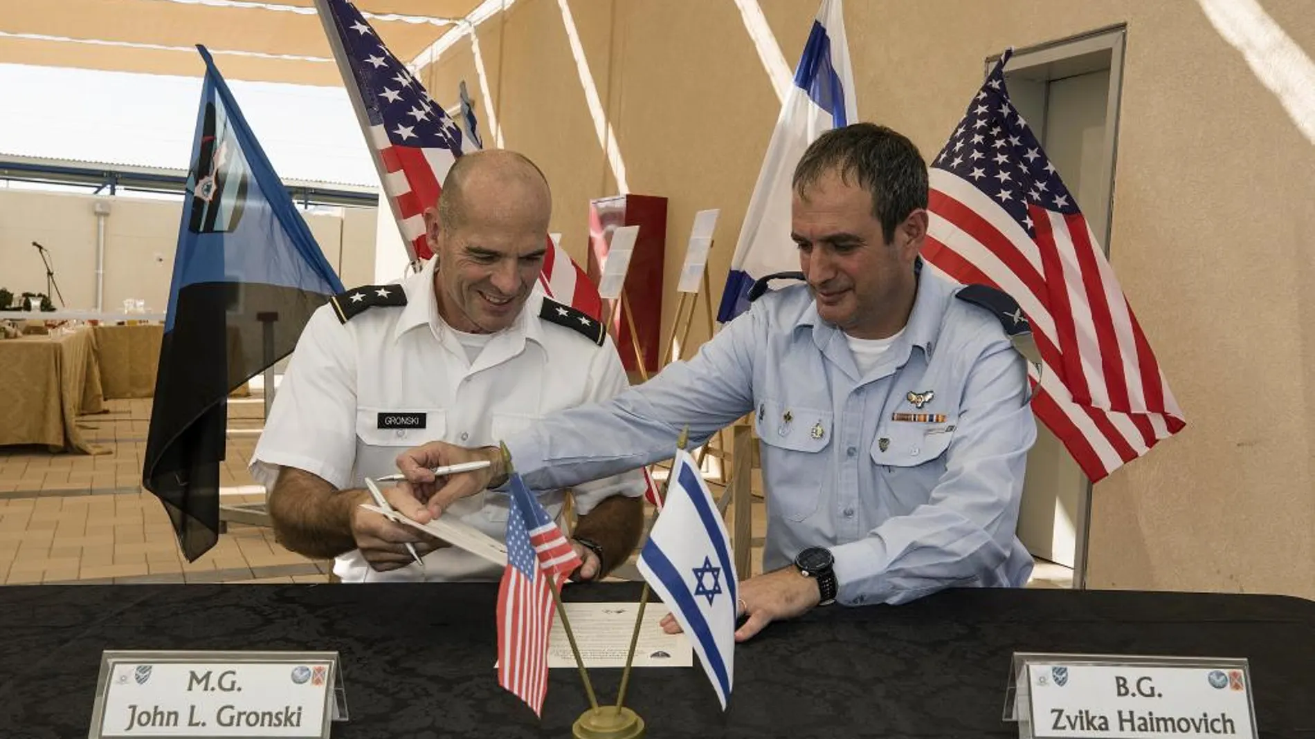 El comandante de la defensa aérea israelí, TZvika Haimovich, a la derecha, junto al general John L. Gronski, firman el acuerdo en la base de Bislach, cercad de Mitzpe Ramon, hoy lunes.