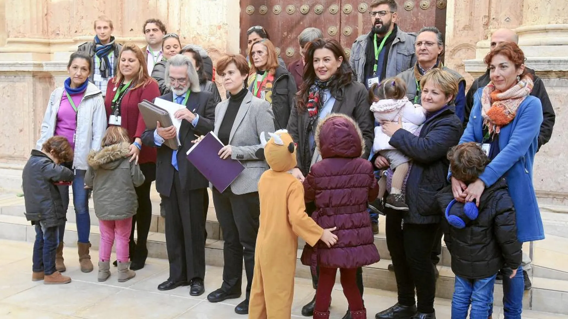 Esperanza Gómez (Podemos) y Antonio Guerrero, de la Plataforma por la Atención Temprana, junto a un grupo de padres y menores con trastornos en el Parlamento