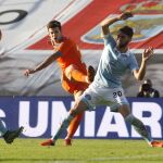 El centrocampista del Valencia, Santi Mina, dispra ante la oposición del jugador del Celta de Vigo, Sergi Gomez