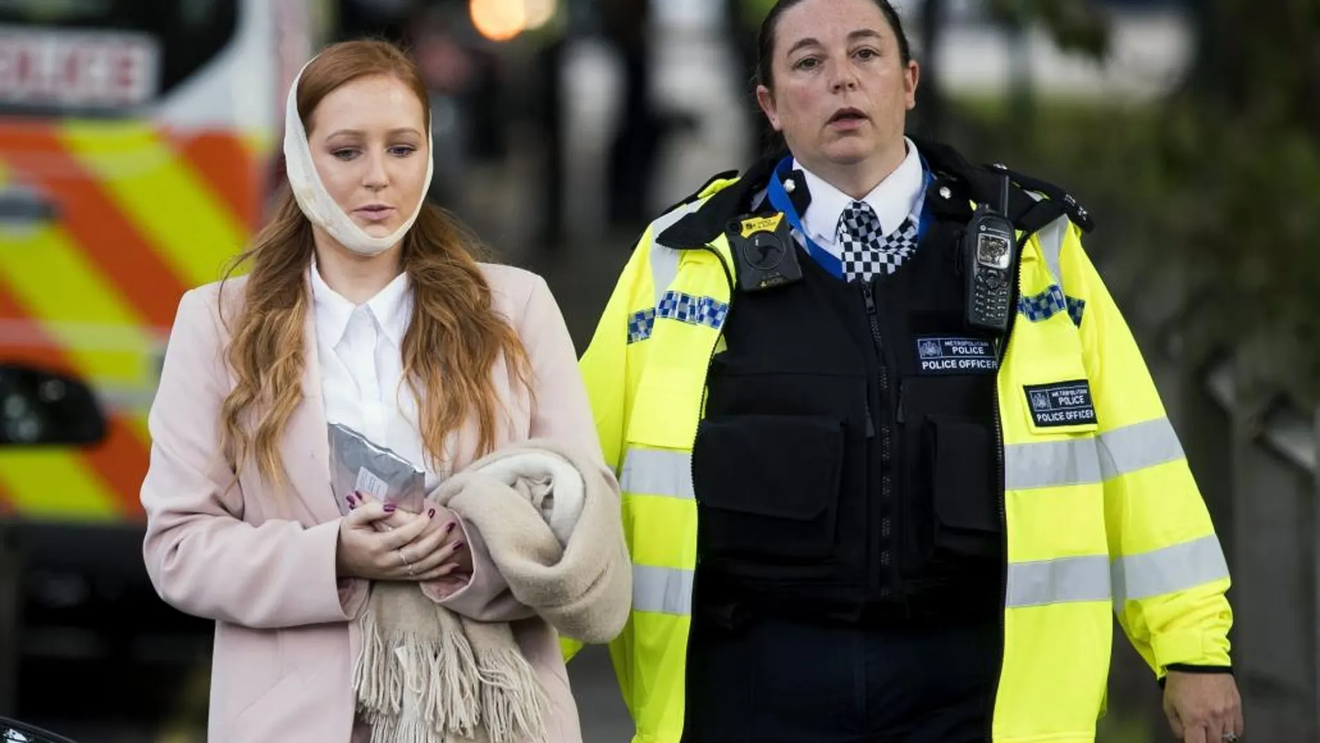 Una agente de policía escolta a una herida en los alrededores de la estación de metro Parsons Green en Londres (Reino Unido)