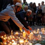 Un grupo de personas encienden velas en recuerdo de las víctimas