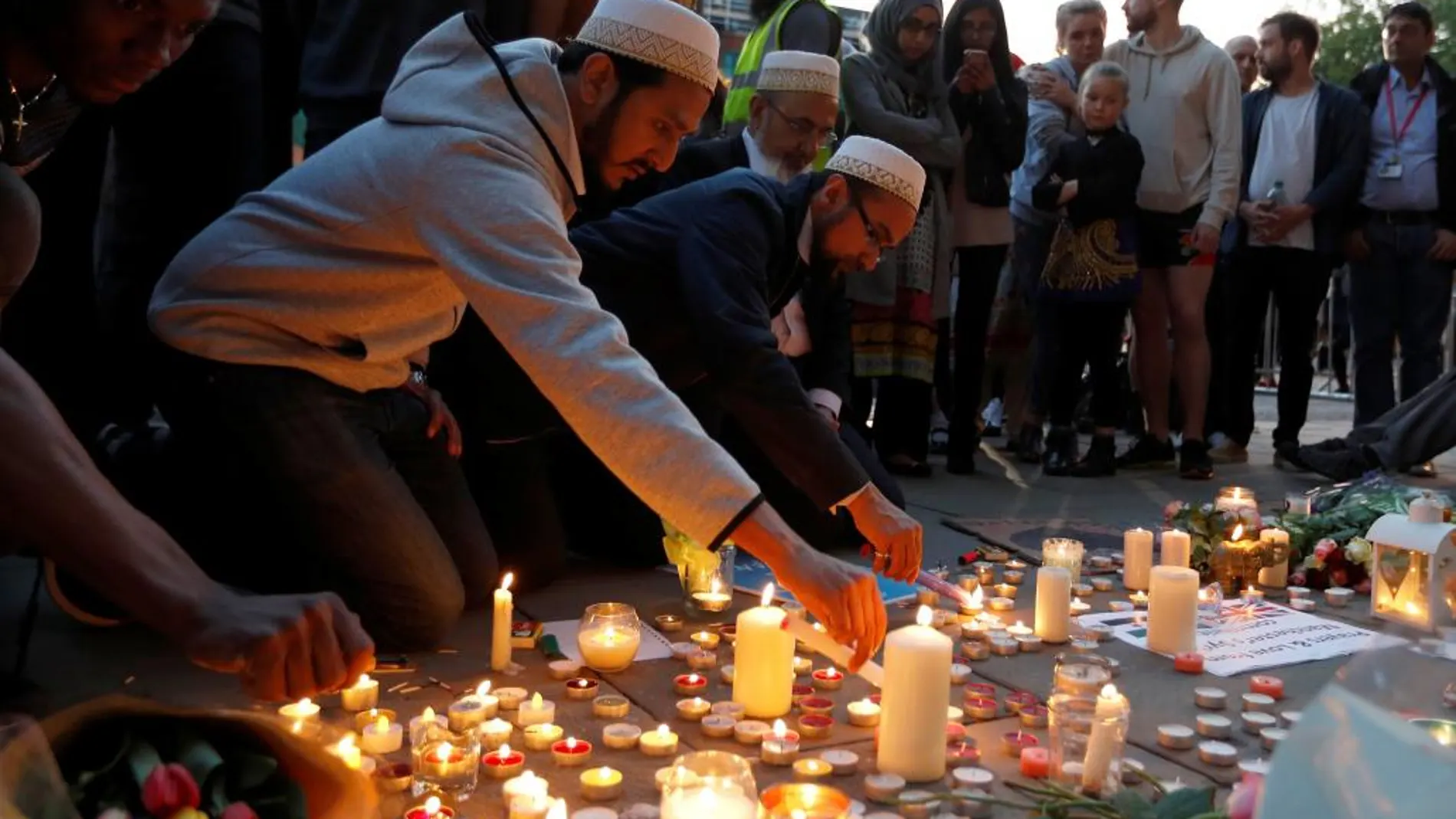 Un grupo de personas encienden velas en recuerdo de las víctimas