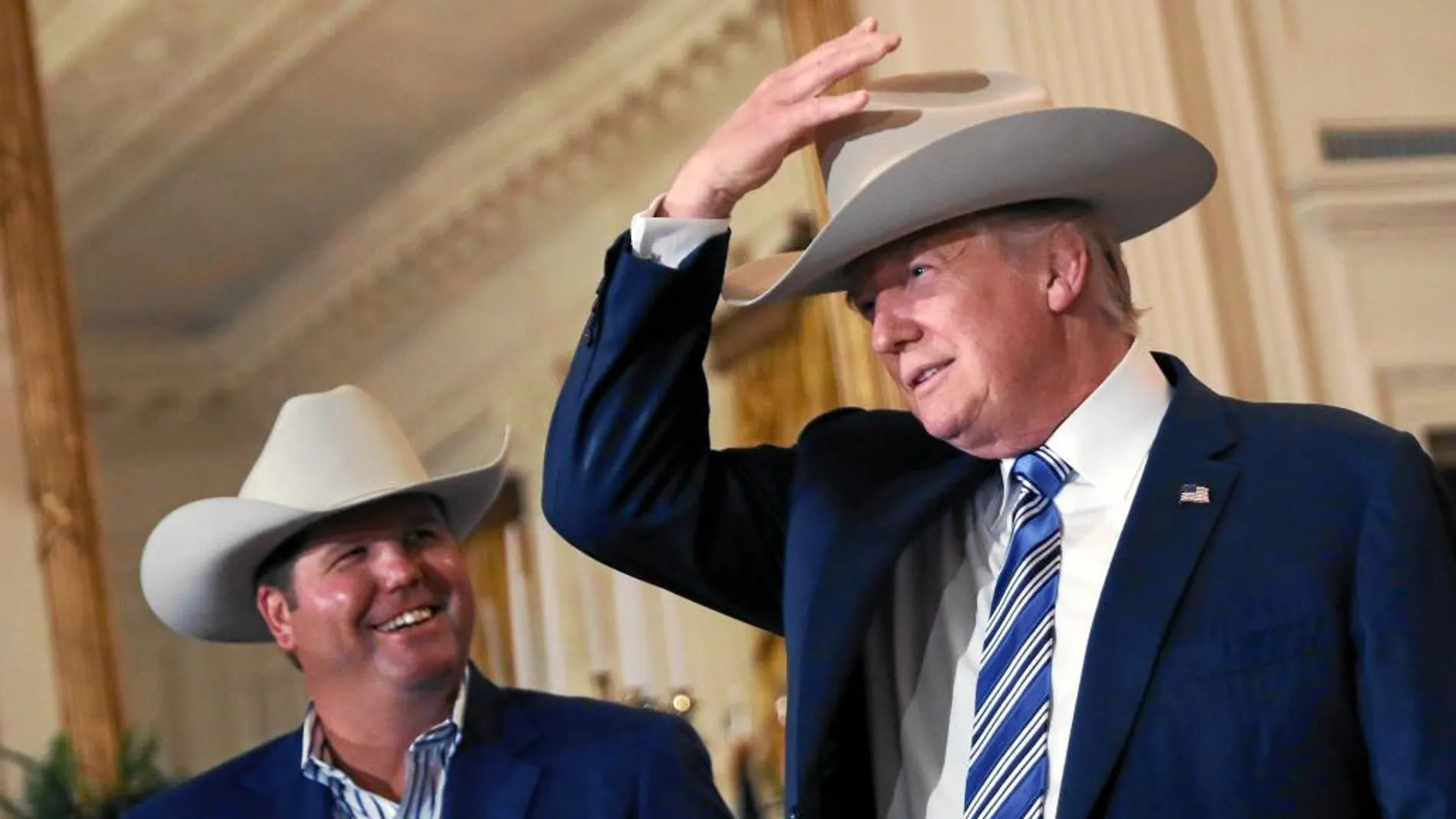 El presidente Trump se prueba un sombrero de vaquero durante una exhibición de productos americanos en la Casa Blanca, ayer