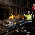 Un vehículo de la policía es atacado por manifestantes hoy, jueves 5 de noviembre de 2015, durante la "Marcha del Millón de Máscaras"en el centro de Londres (Reino Unido)