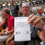 Un hombre muestra una papeleta de voto durante el acto de ayer en el Tarraco Arena