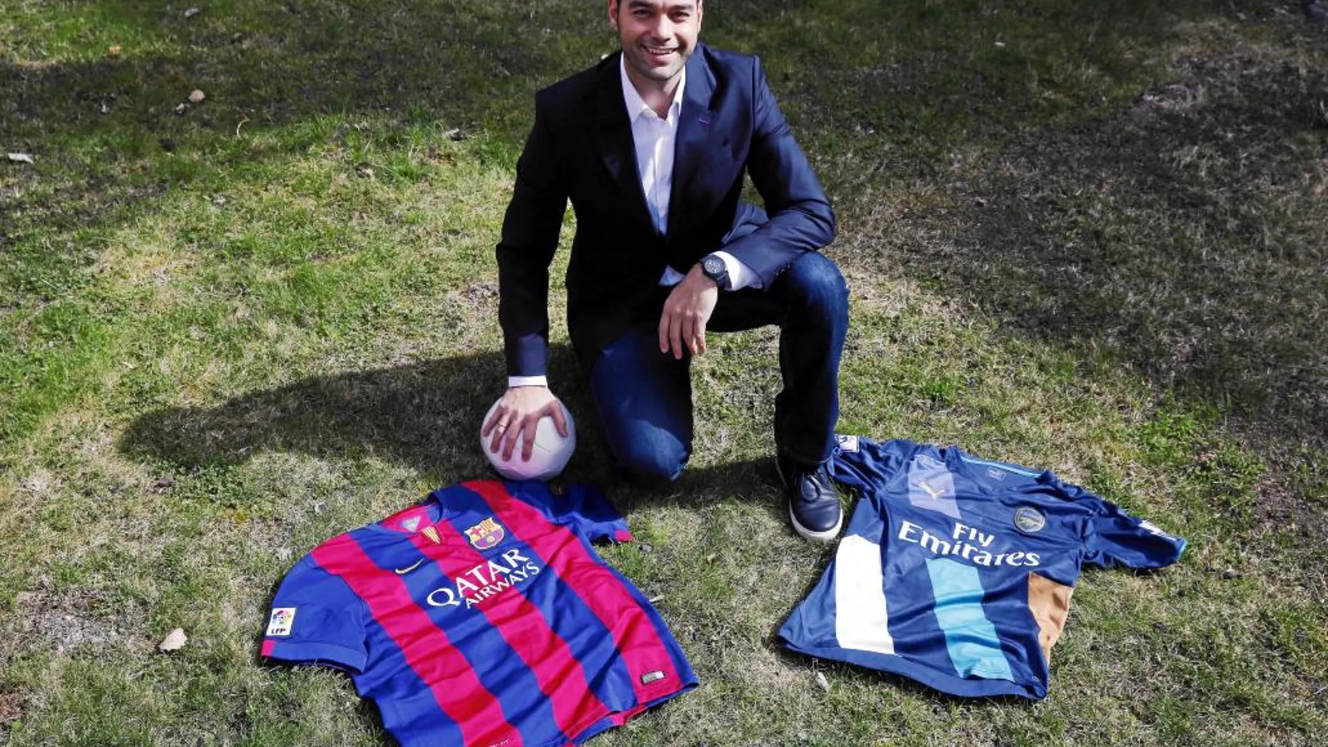 Esteva posa junto a las camisetas del F.C. Barcelona y del Arsenal