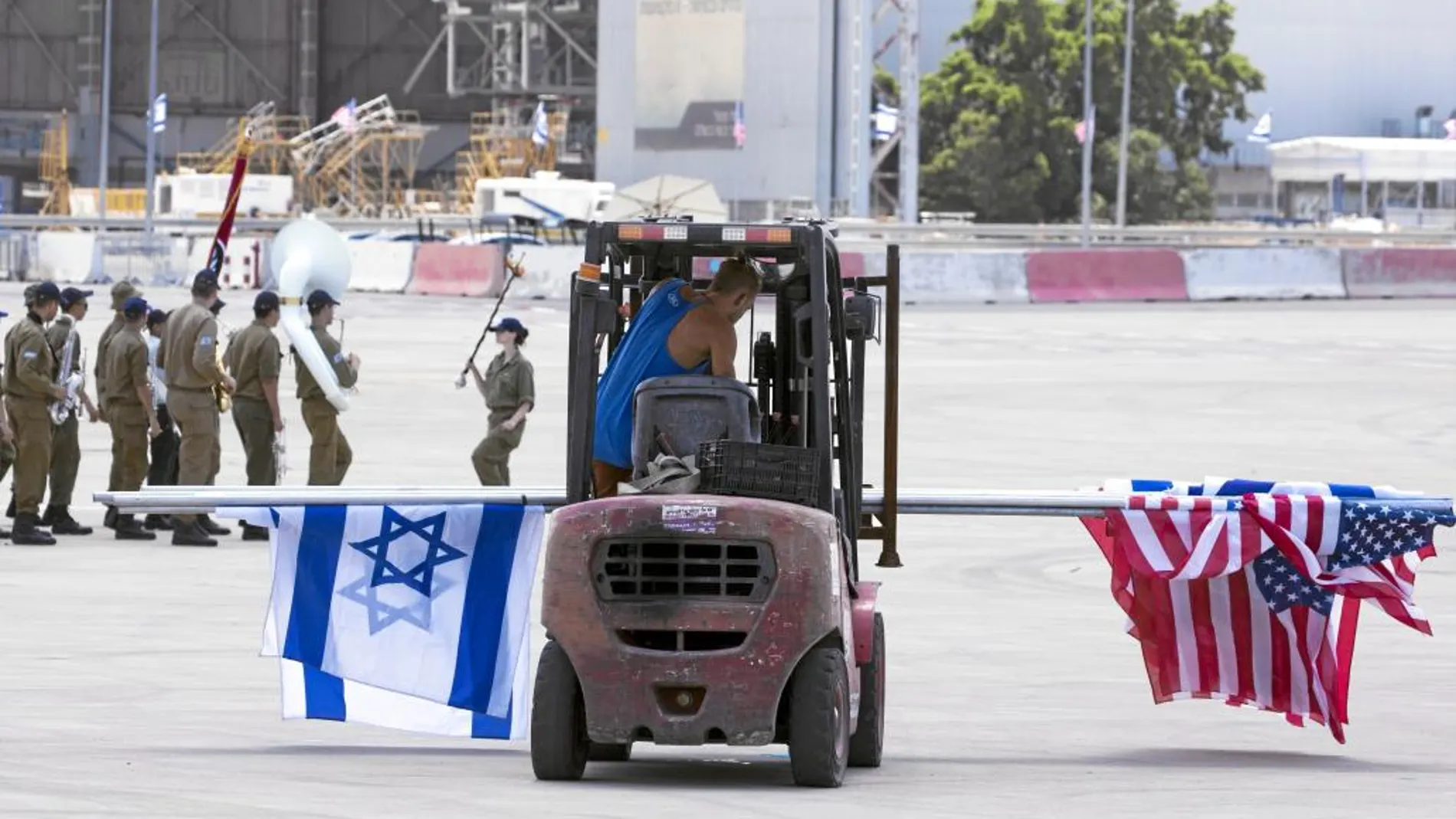 Un operario coloca banderas en el aeropuerto Ben Gurion de Tel Aviv