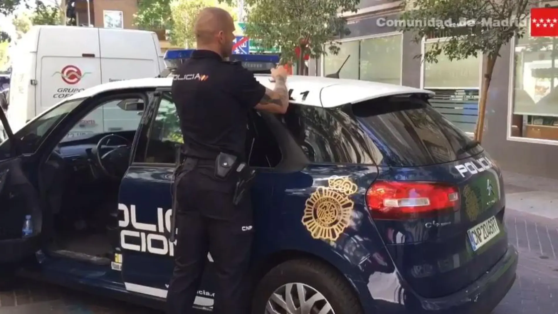 Un agente de la Policía Nacional permanece a las puertas del edificio de Alcorcón en el que ha tenido lugar la agresión.