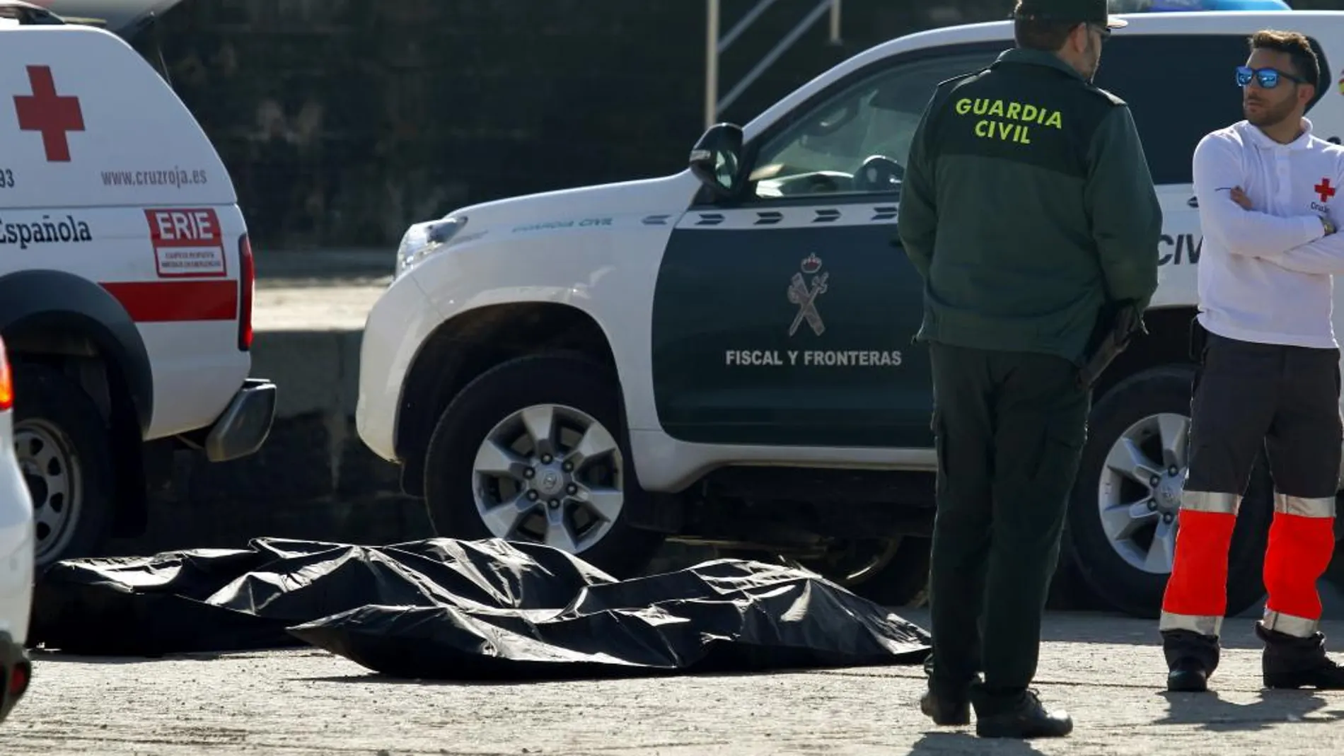 Agentes de la Guardia Civil y de Cruz Roja en el puerto de Algeciras, con dos de los cinco cadáveres de inmigrantes encontrados en las últimas horas