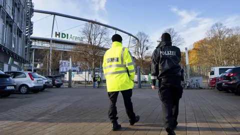 Dos policías pasean en exterior del HDI Arena despúes de la cancelación del partido