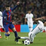 El delantero uruguayo del Paris Saint-Germain Edinson Cavani (d) cae tras la entrada de Gerard Piqué.