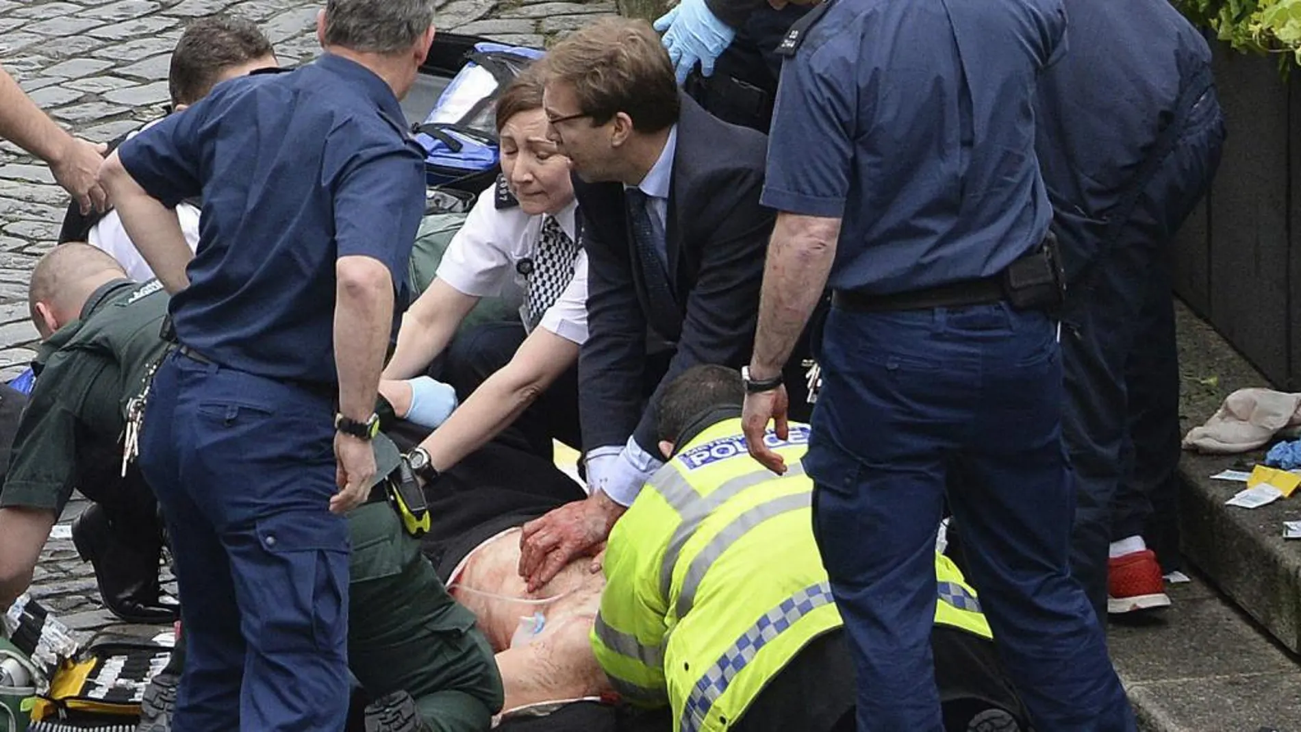 Tobias Ellwood, en el centro con traje y corbata, intenta contener la hemorragia de las heridas del policía