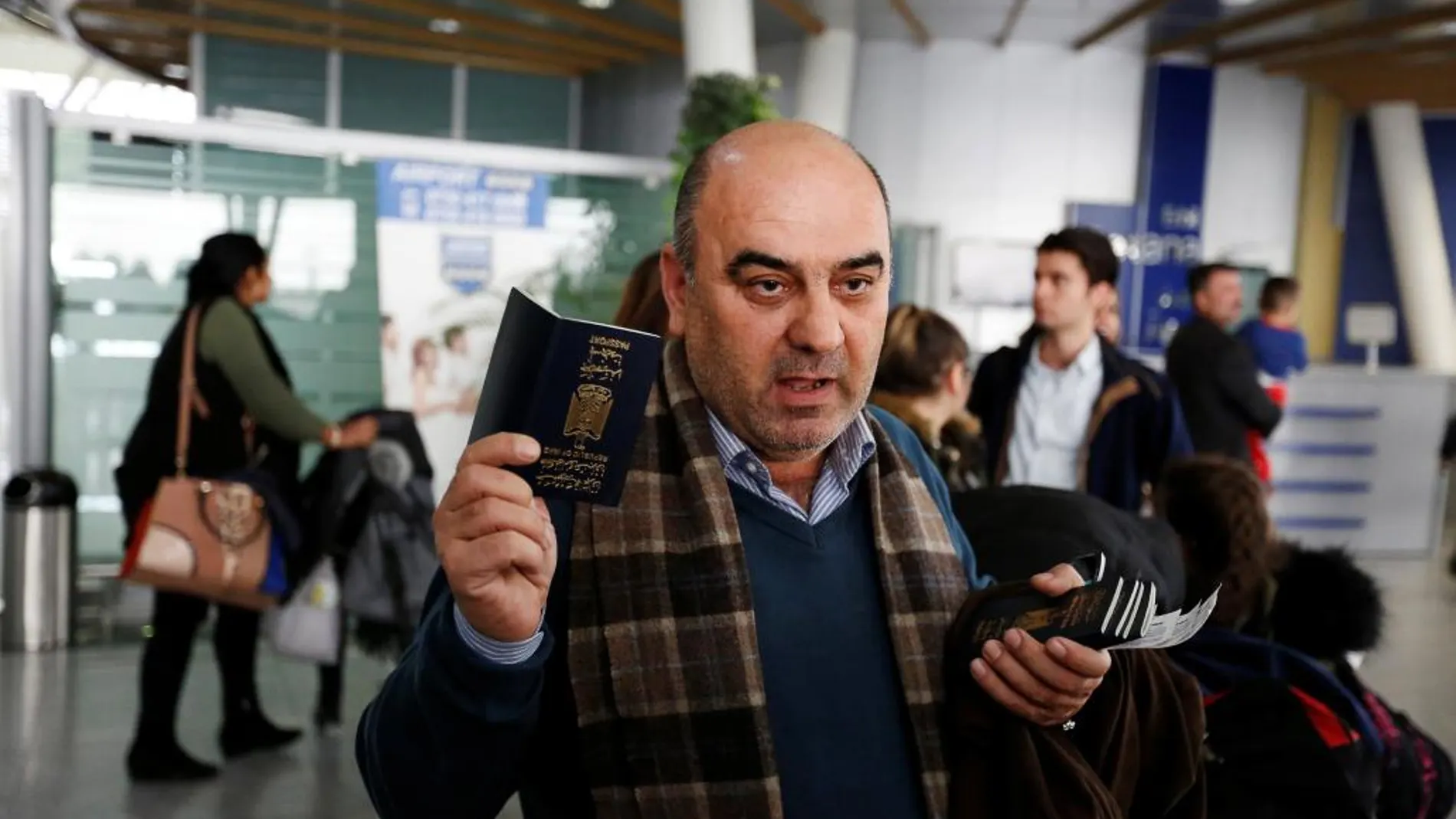 Fuad Sharef Suleman muestra su pasaporte para viajar a EE UU en el aeropuerto de Erbil, en Irak