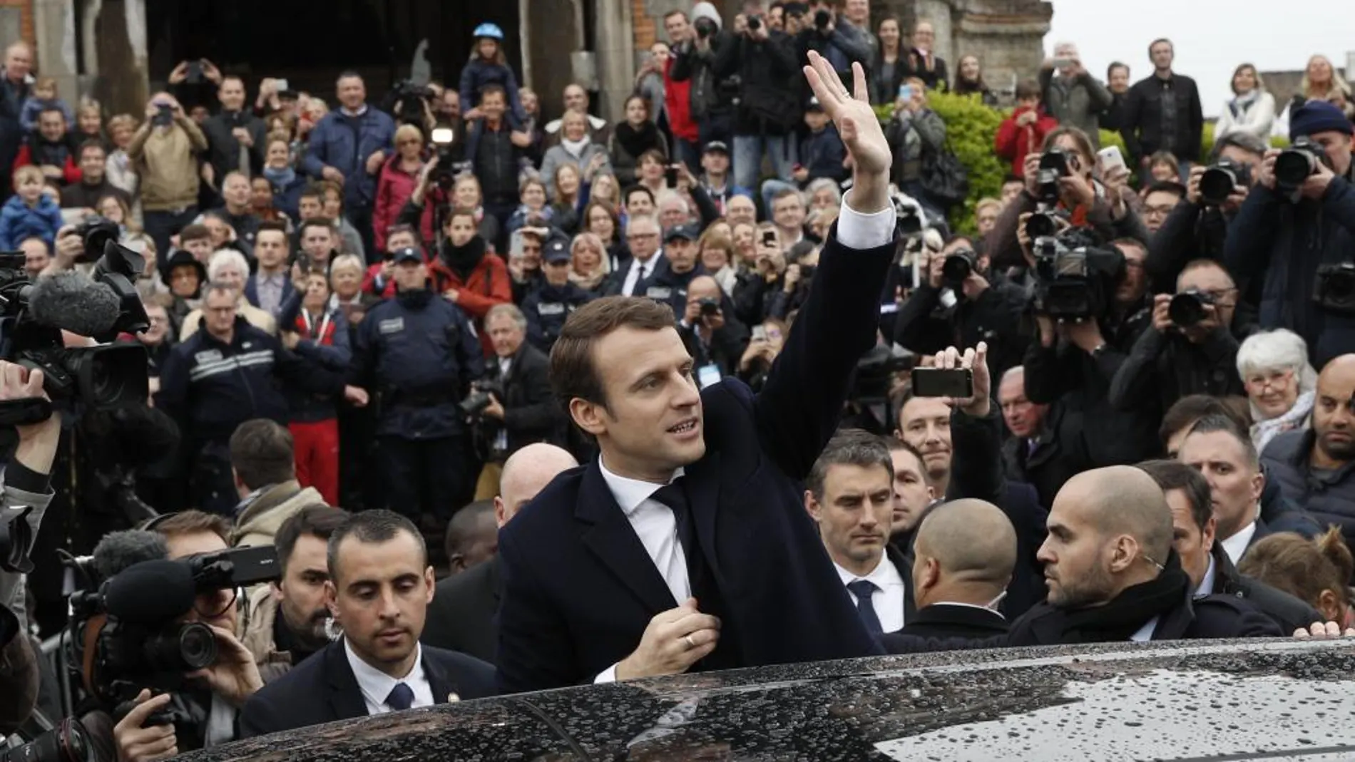 El candidato presidencial galo Emmanuel Macron saluda a los ciudadanos tras ejercer su derecho al voto