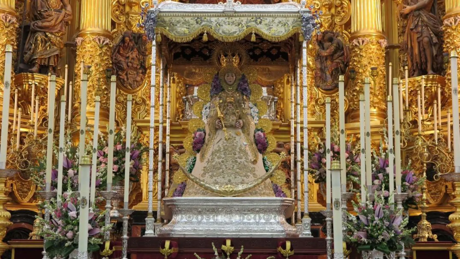 La Virgen luce el traje de los Montpensier, la corona de la coronación, el rostrillo de Muñoz y Pabón y las ráfagas de punta de martillo o redondas