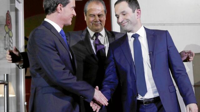 Tras la batalla. Manuel Valls (izda.) y Benoît Hamon se dan anoche la mano a la entrada de la sede del Partido Socialista en París