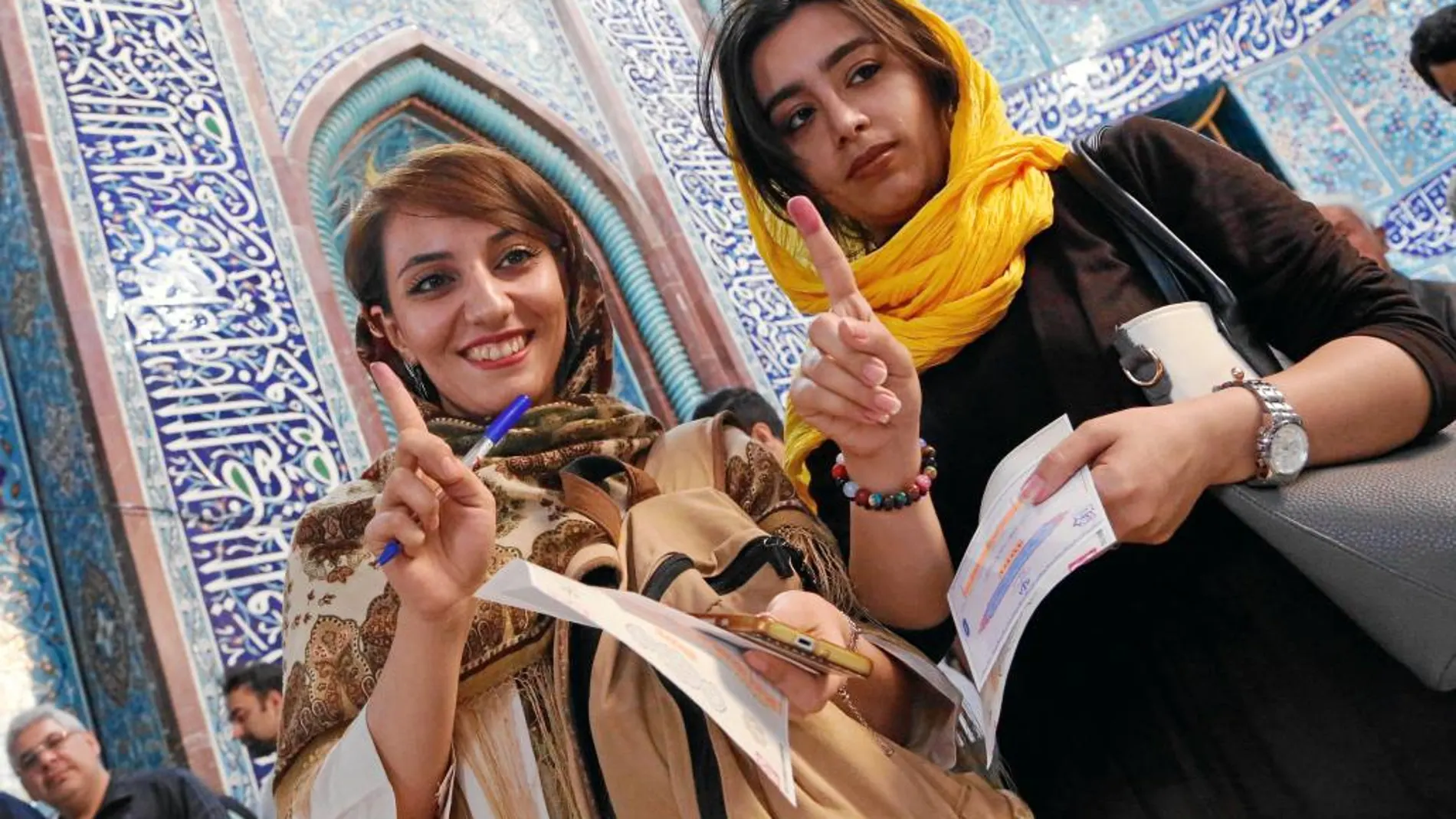 Dos mujeres muestran sus huellas tras votar para las elecciones presidenciales en Teherán (Irán)