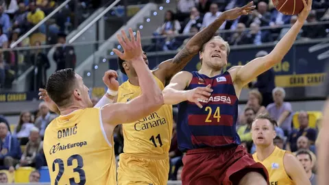 El escolta del FC Barcelona Lassa Brad Oleson (c) tira a canasta ante el pívot Alen Omic (d), y el escolta Dennis Seeley (c) del Herbalife Gran Canaria durante el partido