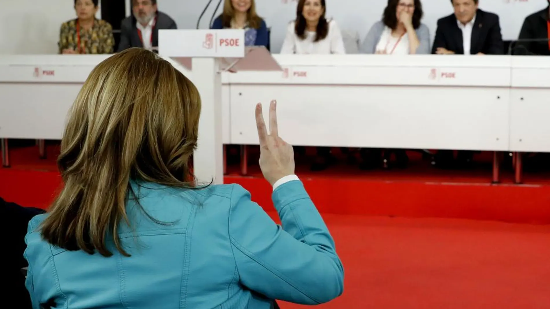 Susana Díaz (de espaldas) se dirige a los miembros de la mesa presidencial durante la reunión del Comité Federal del PSOE.