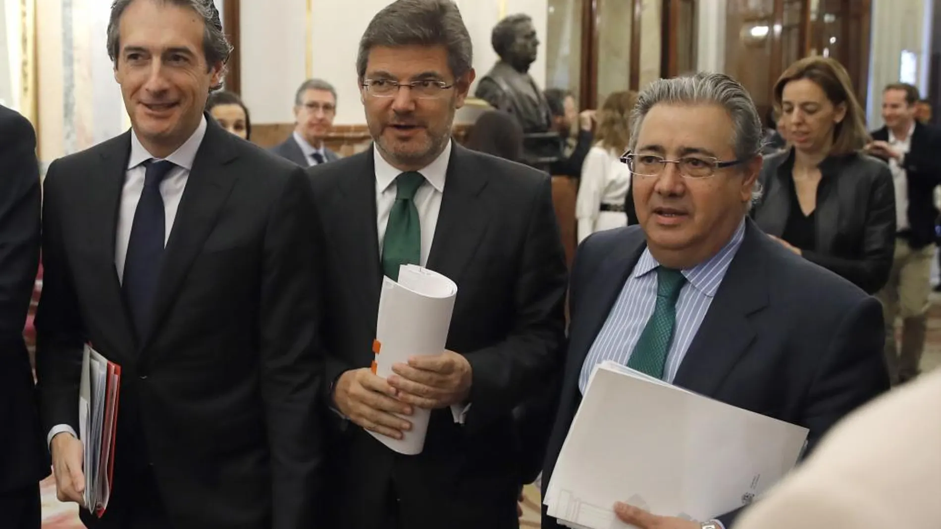 Los ministros, de Fomento, Íñigo de la Serna (i); de Justicia, Rafael Catalá (c), y del Interior, Juan Ignacio Zoido (d), en los pasillos del Congreso