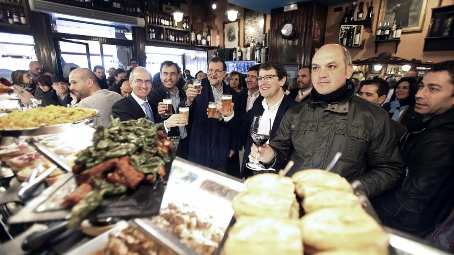 El presidente del PP y del Gobierno en funciones, Mariano Rajoy (c), junto al alcalde de Salamanca, Alfonso Fernández Mañueco (3d), durante un paseo hoy por la ciudad castellanoleonesa