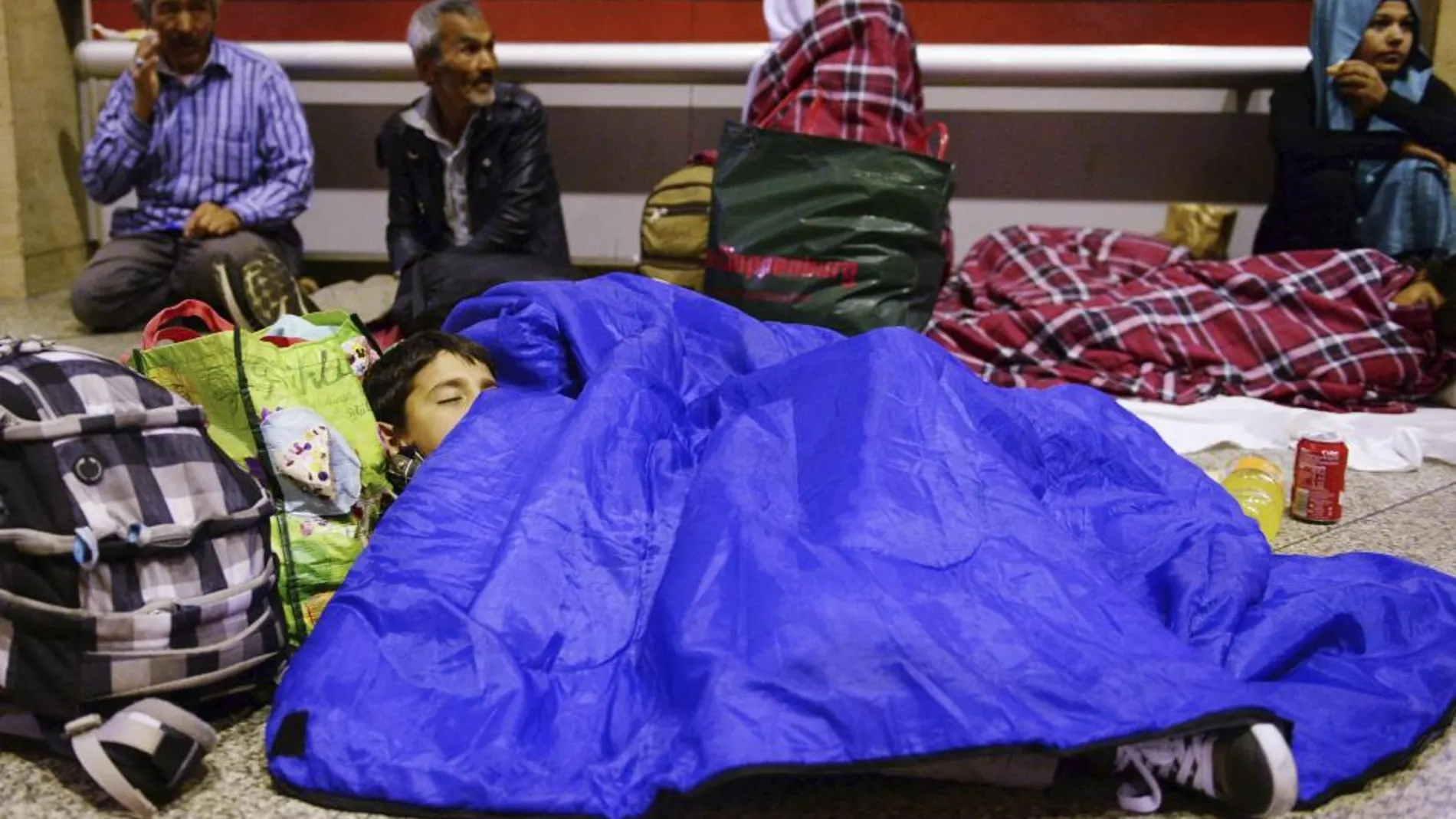 Un niño refugiado procedente de Afganistán duermen en la estación de tren de Múnich a última hora de ayer
