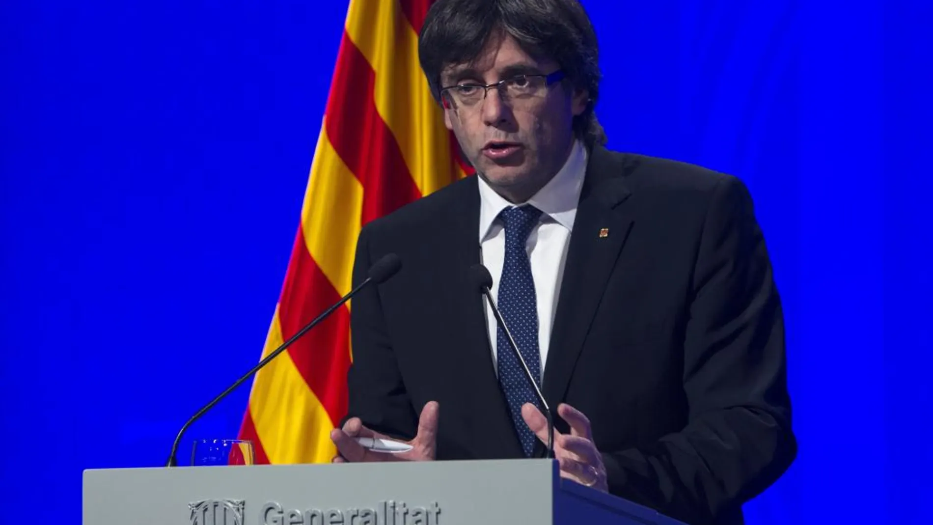 El presidente de la Generalitat, Carles Puigdemont, atiende a los medios de comunicación después de presidir la cumbre política y social en defensa de la ley de emergencia social frente al recurso del Gobierno central