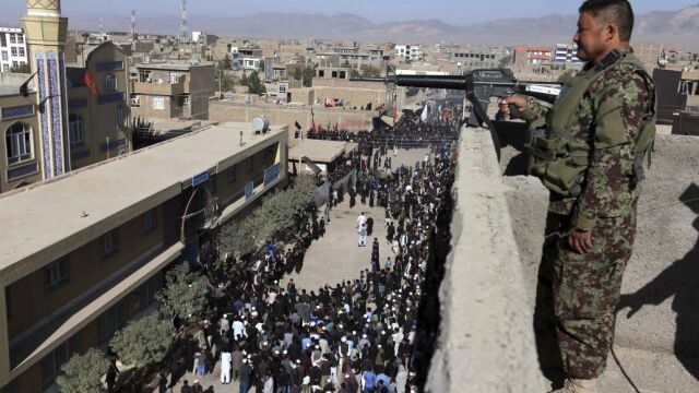 Un guarda de seguridad vigila desde la azotea de un edificio durante una procesión chií para conmemorar el Ashura, en Herat, Afganistán