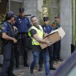 Mossos d'Esquadra y Policía Nacional transportan cajas con pruebas incautadas hoy en una operación en Barcelona