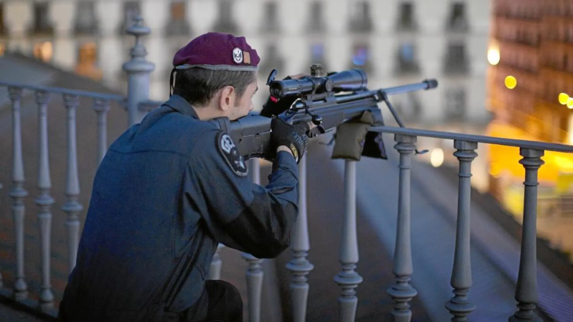 Un agente de los Mossos d’Esquadra toma posiciones en una terraza con un arma larga