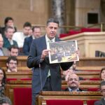 García Albiol, ayer en el Parlament,mostrando una fotografía del acto del Govern en una sala del Europarlamento con simpatizantes independentistas.