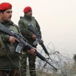 Miembros de los servicios de seguridad afganos hacen guardia en una carretera, en Kabul