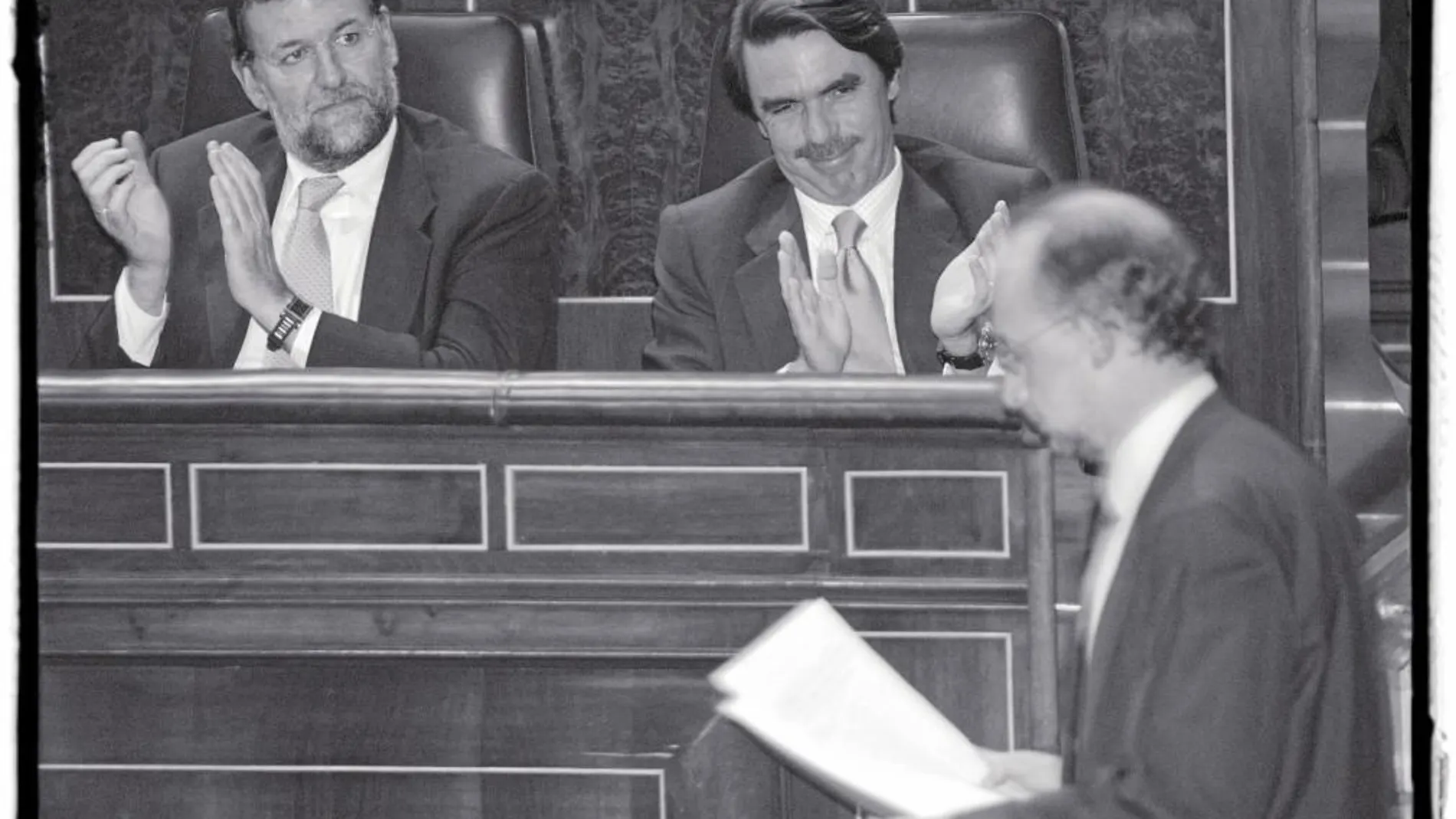 Mariano Rajoy y José María Aznar aplauden a Cristóbal Montoro en el Congreso en 2002