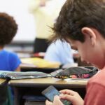 Un niño juega con su móvil durante una clase en Francia / Dreamstime