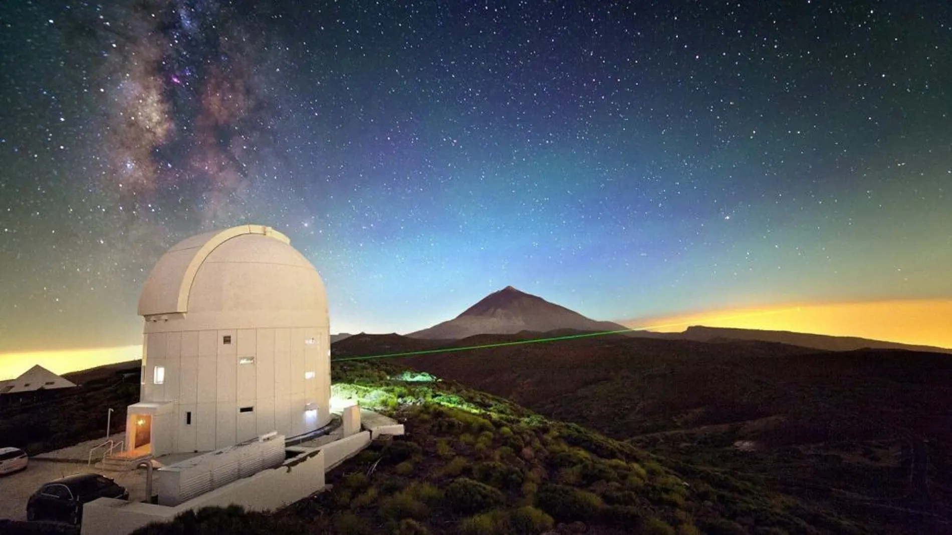 Imagen cedida por Mario Krenn, investigador del Instituto de Óptica e Información Cuántica (IQOQI) de Viena, de una de las transmisiones de datos por láser realizadas desde la cumbre de La Palma hasta la de Tenerife, en la que se observa el haz de luz atravesando el cielo nocturno sobre la Caldera de Taburiente, con el Teide al fondo.