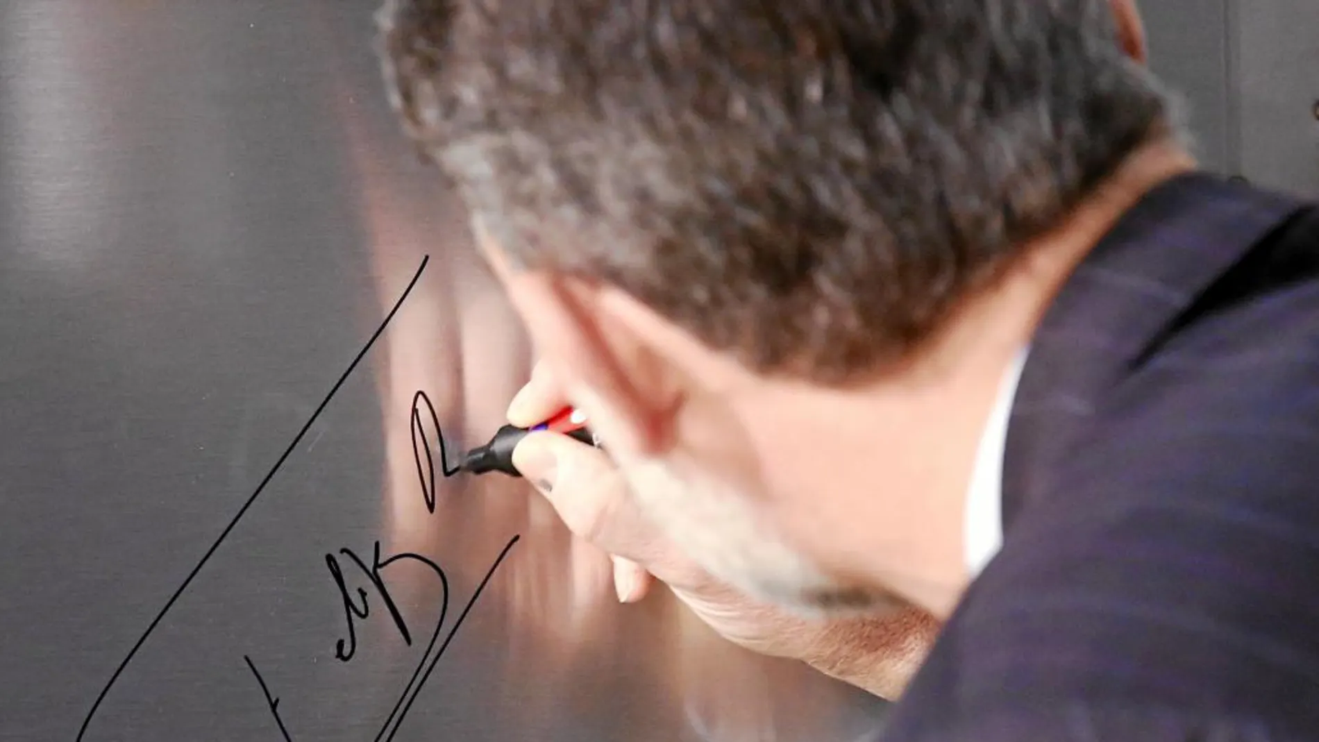 Don Felipe estampa su firma en una imagen de archivo