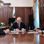 Vladimir Putin (C) durante la reunión que ha mantenido con sus ministros de Exteriores, Sergei Lavrov (L) y de Defensa, Sergei Shoigu (R).