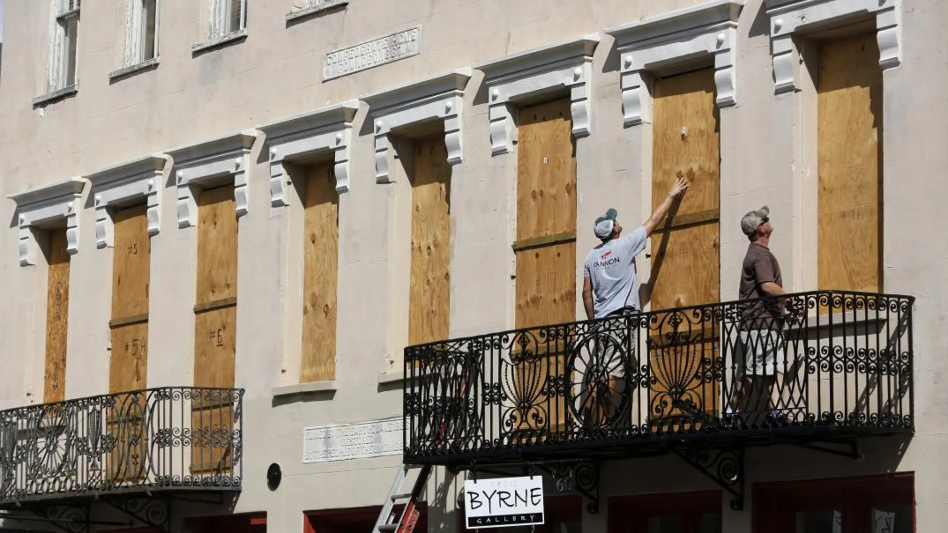 Varias personas tapian las ventanas de un edificio en Charleston ante la llegada del huracán Florence/Foto: Ap