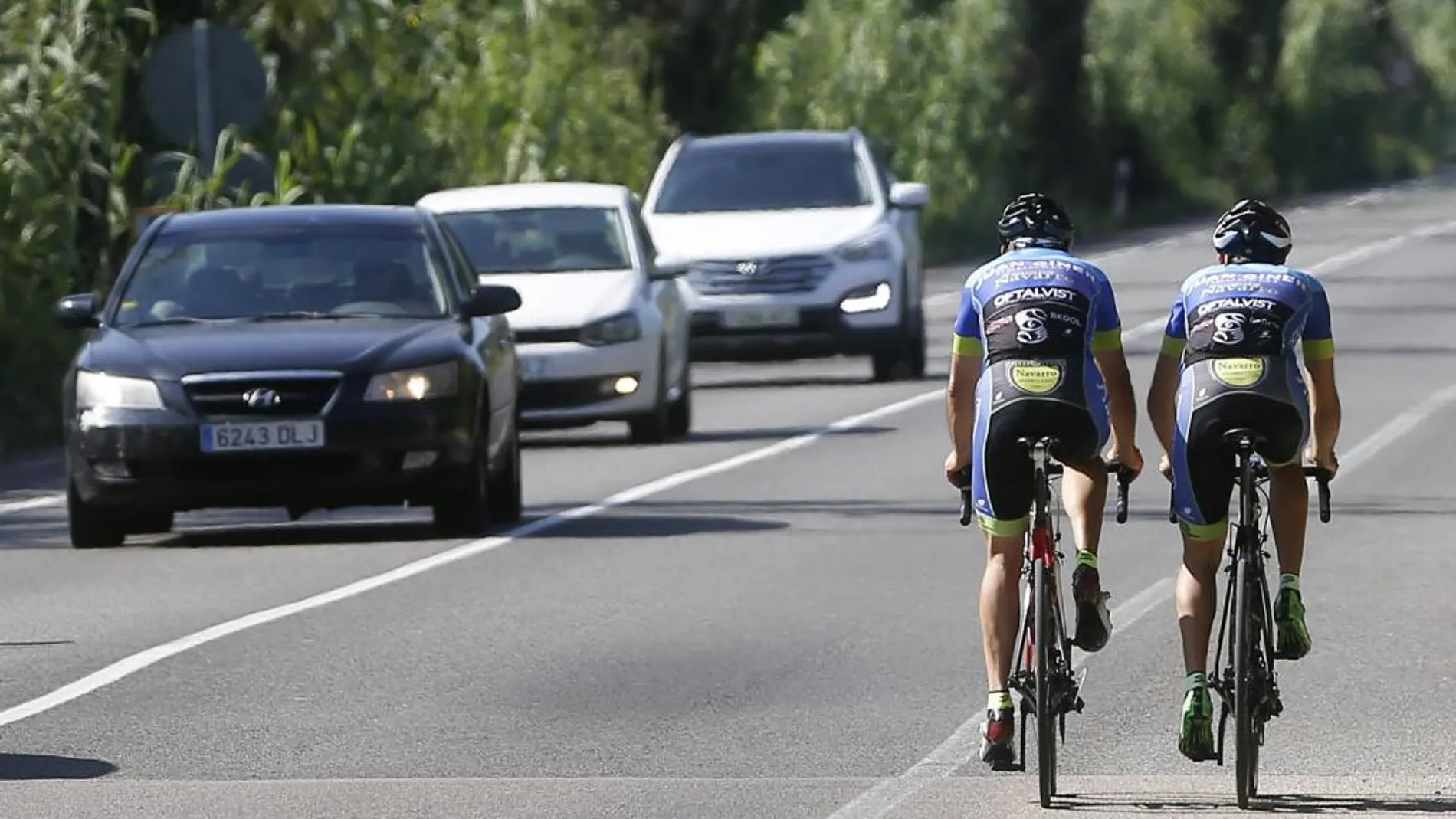 Dos ciclistas circulan por la carretera de El Saler, Valencia