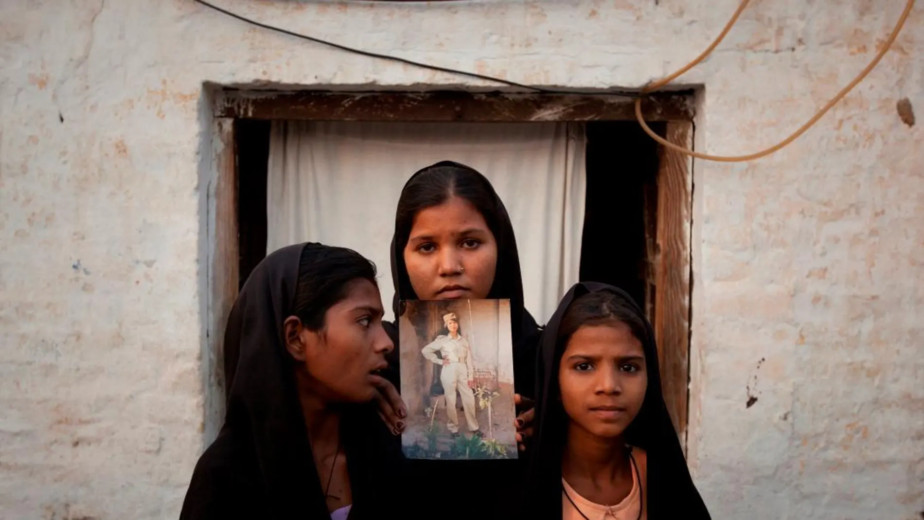 Las hijas de Asia Bibi posan con una foto de su madre en su casa de Sheikhupura, en Pakistán/Foto: Reuters